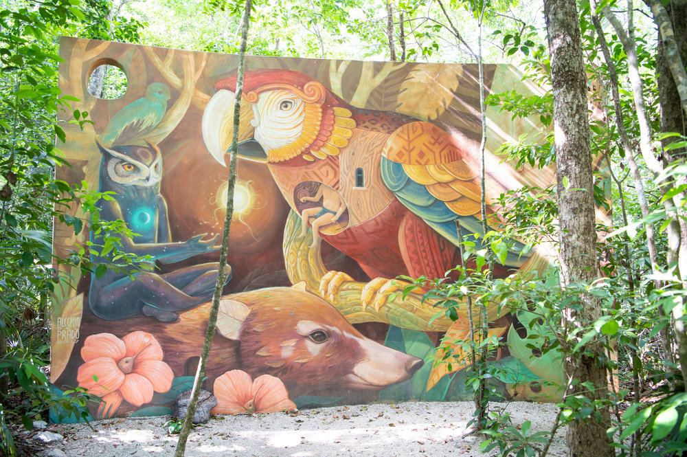Colorful mural surrounded by jungle at Holistika